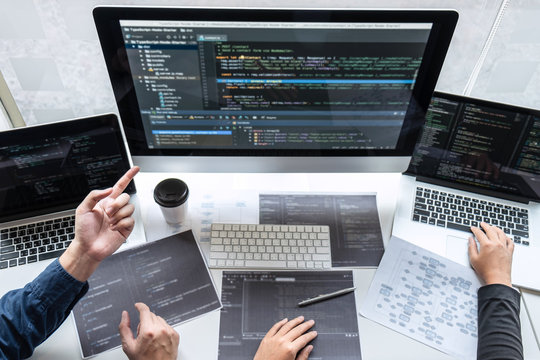 Team of developer programmer working on project in software development computer in IT company office, Writing codes and data code website and coding database technologies to find problem solution