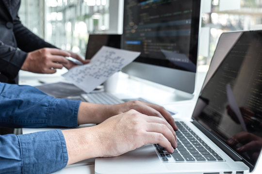 Team of developer programmer working on project in software development computer in IT company office, Writing codes and data code website and coding database technologies to find problem solution