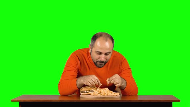 Caucasian man appearance eats french fries, then makes funy faces with her