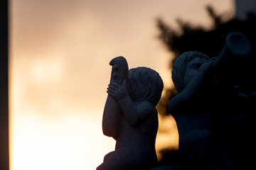 sunset and the silhouette of an angel-shape stone structure