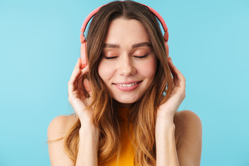 Portrait of beautiful joyous woman wearing headphones listening to music