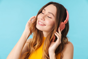 Portrait of beautiful joyous woman wearing headphones listening to music