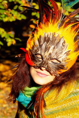 Young woman with a colorful feather face mask.