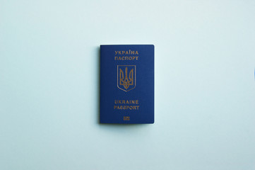 One Ukrainian biometric passport on a light blue background. Travel concept