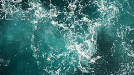 Fototapeta na wymiar Background of the sea, clean deep ocean with air bubbles, foam on the surface of the ocean. foam composition on blue turquoise water.