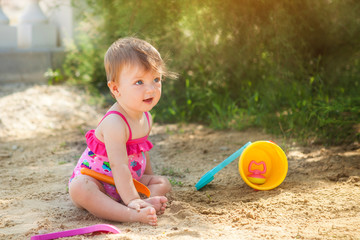 Baby girl playing on beach.