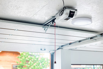 Opening door and automatic garage door opener electric engine gear mounted on ceiling with...