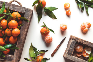 tangerines with fresh leaves in wooden box isolated on white, isolated on a white, top view