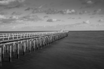 Felixstowe pier protrudes into the sea in black and white