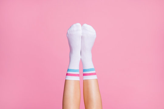 Cropped close-up view of nice vertical feminine legs wearing white casual soft cotton comfortable socks new brandy collection isolated over pink pastel color background