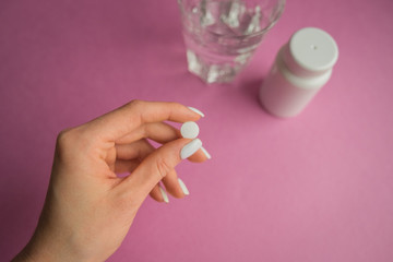 White and yellow pills on a pink background. Dosage of medication. Assorted pills in the shape of a heart. oral contraceptives. Cardiology