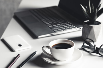 Business man using laptop computer with pen glasses and cup of hot coffee