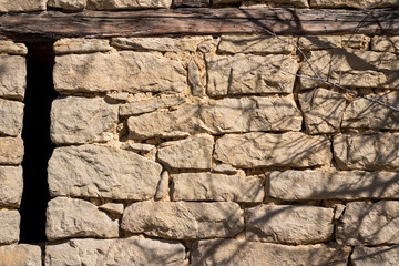 Stone fence wall, stone house. Hard slate slab rock texture, natural narrow brick, beige, yellow, gray