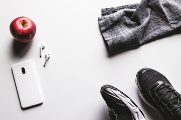 Mockup mobile cellphone with earphone and running shoes on white background. Healthy lifestyles