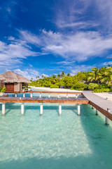 Fototapeta premium Exotic landscape of Maldives beach. Tropical panorama, luxury water villa resort with wooden pier or jetty. Luxury travel destination background for summer holiday and vacation concept.