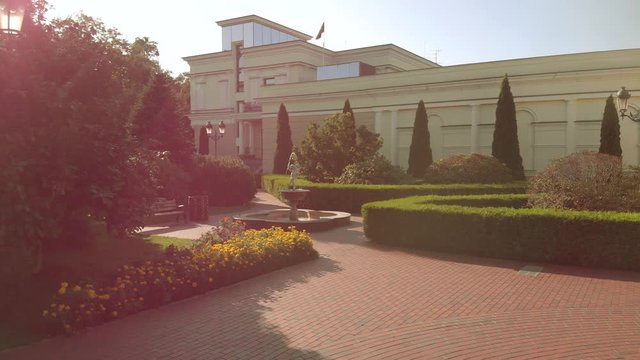Decorative fountain in a well-groomed mansion yard. Cobblestone floor, sunny park.