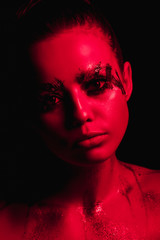 Studio portrait of a girl in red light on a black background