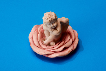 gypsum angel figurine on a blue background.
