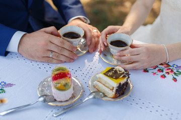romantic dinner with two pieces of cake close up. man and woman talking over coffee time in cafe. young couple in love on served table on the romantic date. romantic moment close up