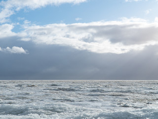 Scenery of a beautiful cloudy sky over an ice-covered pond