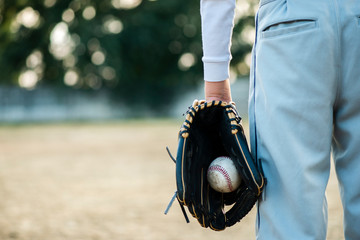 Back view of man holding baseball in glove
