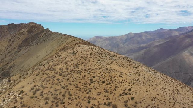An aerial view inside Andes mountains at Limari Valley, south Atacama. An amazing wild scenery. Arid idyllic valleys with green farm fields feed in by the river at the bottom of the valley

