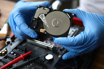 Gloved hands show computer hard drive, need repair. File system repair and recovery. Free diagnosis...
