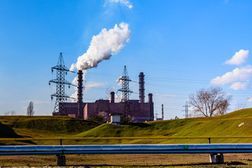 View on smoke pipes of the factory against blue sky. Environmental pollution