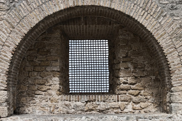 Window with fence in an old wall of Vejer de la Frontera, Spain