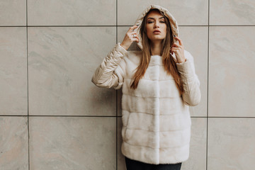 Fashion concept. Girl elegant lady wear fashionable coat jacket with furry hood. Luxurious fur. Girl posing hooded fur coat. Woman wear hood with fur.