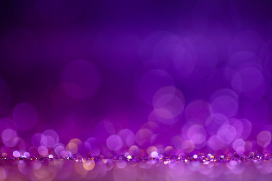 Decoration twinkle lights background, abstract blurred backdrop with circles,modern design wallpaper with sparkling glimmers. Purple, blue and golden backdrop glittering sparks with blur effect