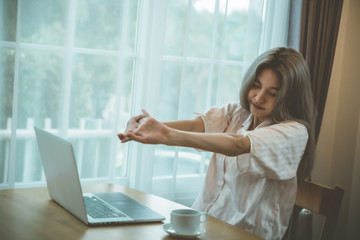 Lazy bored asian woman using laptop in the morning.