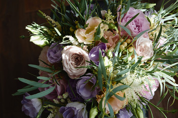 Closeup of lush bridal bouquet of pink, beige, purple flowers and greenery, copy space. Wedding concept. Top view, flat lay