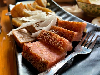 A burmese(myanmar) style baked banana rice cake in the plate with fork which is very famous in myanmar