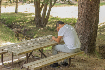 Fototapeta premium A man sat in the country in a silent and thoughtful position