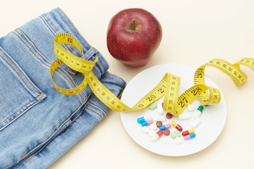 A ruler and red apple for measuring waistline on jeans