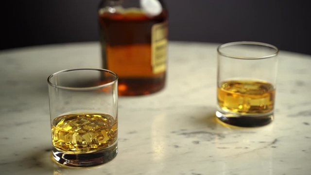 Golden whiskey with ice cubes in crystal clear glasses on marble table, tasty brandy drink for holidays and celebration. Alcohol whisky in local pub, amber scotch beverage