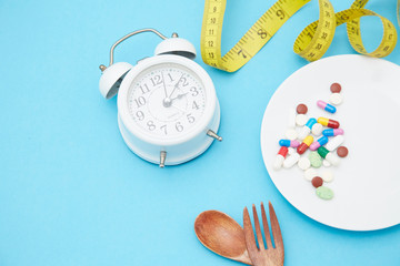 Diet pills and scales on the plate