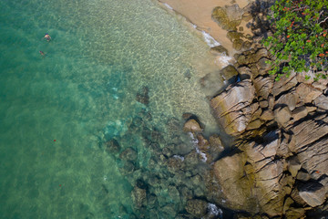 Aerial drone top view of turquoise sea surface with stones and rocks in water