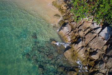 Aerial drone top view of turquoise sea surface with stones and rocks in water