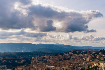 Fototapeta na wymiar The panoramic view of a medieval French town in Côte d'Azur under the cloudy moody sky and warm sunlight