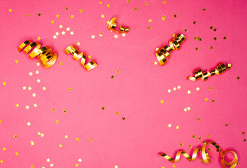 Golden decorations and sparkles on pink background