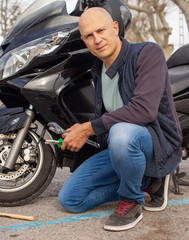 Confident young man is going to repair a motorcycle