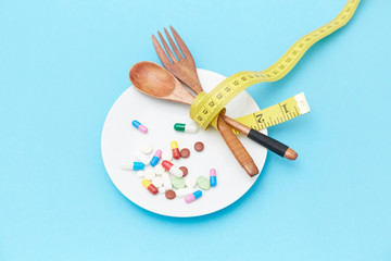 Diet pills and scales on the plate