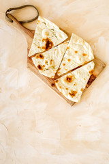 Make focaccia. Traditional italian bread on cutting board on beige table top-down copy space