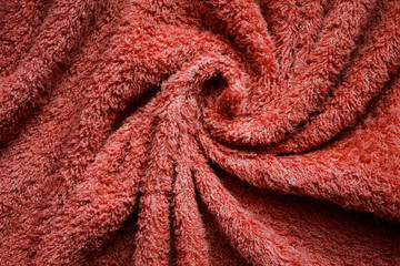 texture of a spiral- folded Terra-cotta Terry towel in close-up with a blurred background