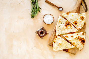 Italian focaccia with cheese and rosemary on beige background top-down copy space