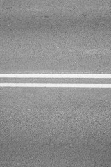 Fototapeta premium close-up of a road with continuous lines painted white horizontally
