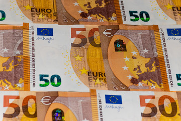 A close-up shot of a heap of 50 (fifty) euro banknotes: background / illustration