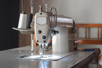 White industrial sewing machine use sew cloth close-up.